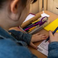 Student merchant works on drawing a picture during Student Small Business Market.